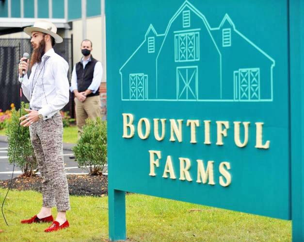 General Manager, Zachary Taylor with Sign at Bountiful Farms Natick Dispensary - Credit Art Illman (Wicked Local / Metro West Daily News)